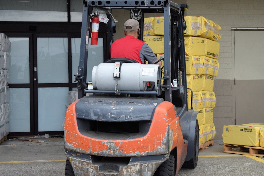 Forklift operator moving palletised stock at a warehouse dock